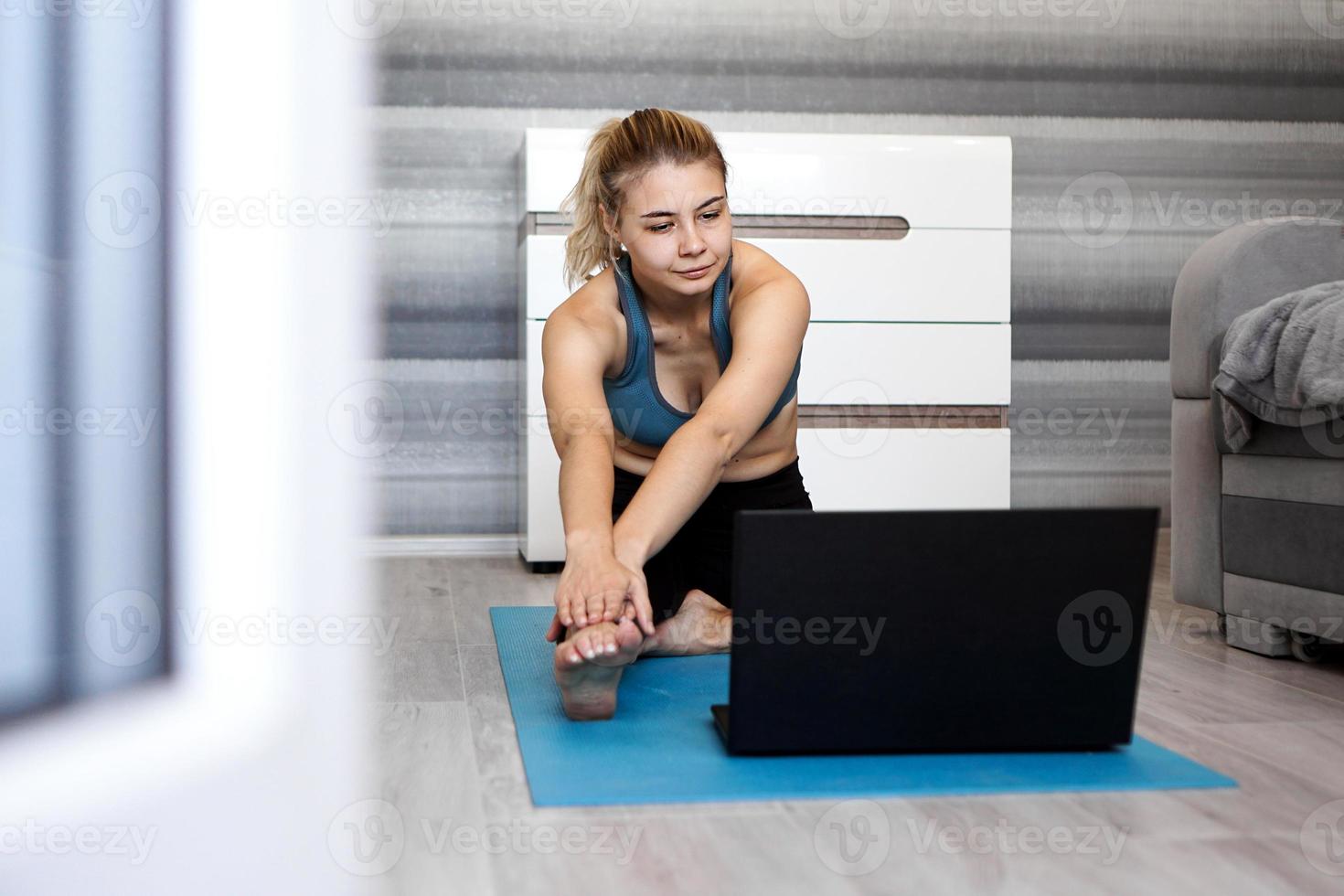 kvinna i sportkläder tittar på online -video på bärbar dator foto