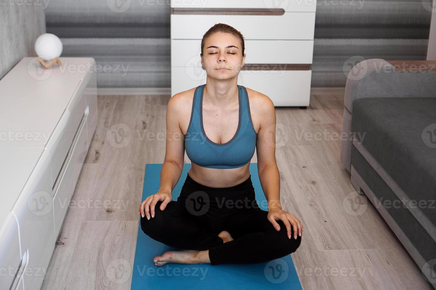 yoga hemma. håll dig lugn. attraktiv ung kvinna sitter foto