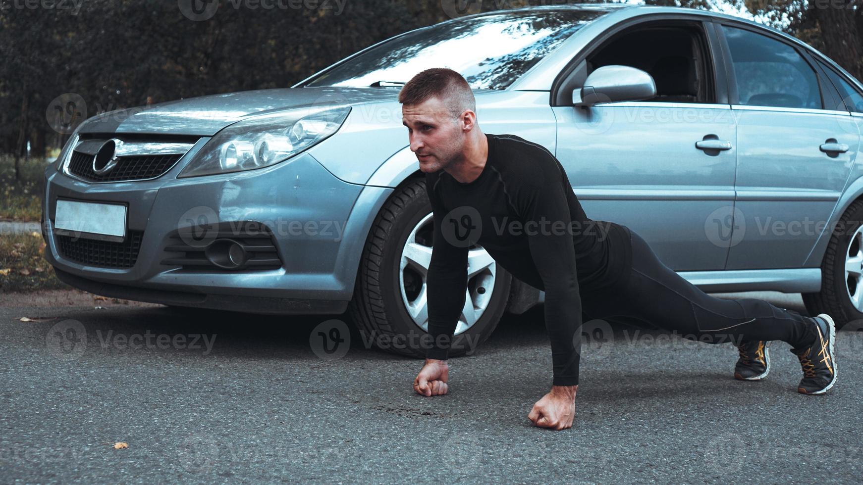 stilig man nära bilen. idrottaren vred ut bredvid maskinen foto