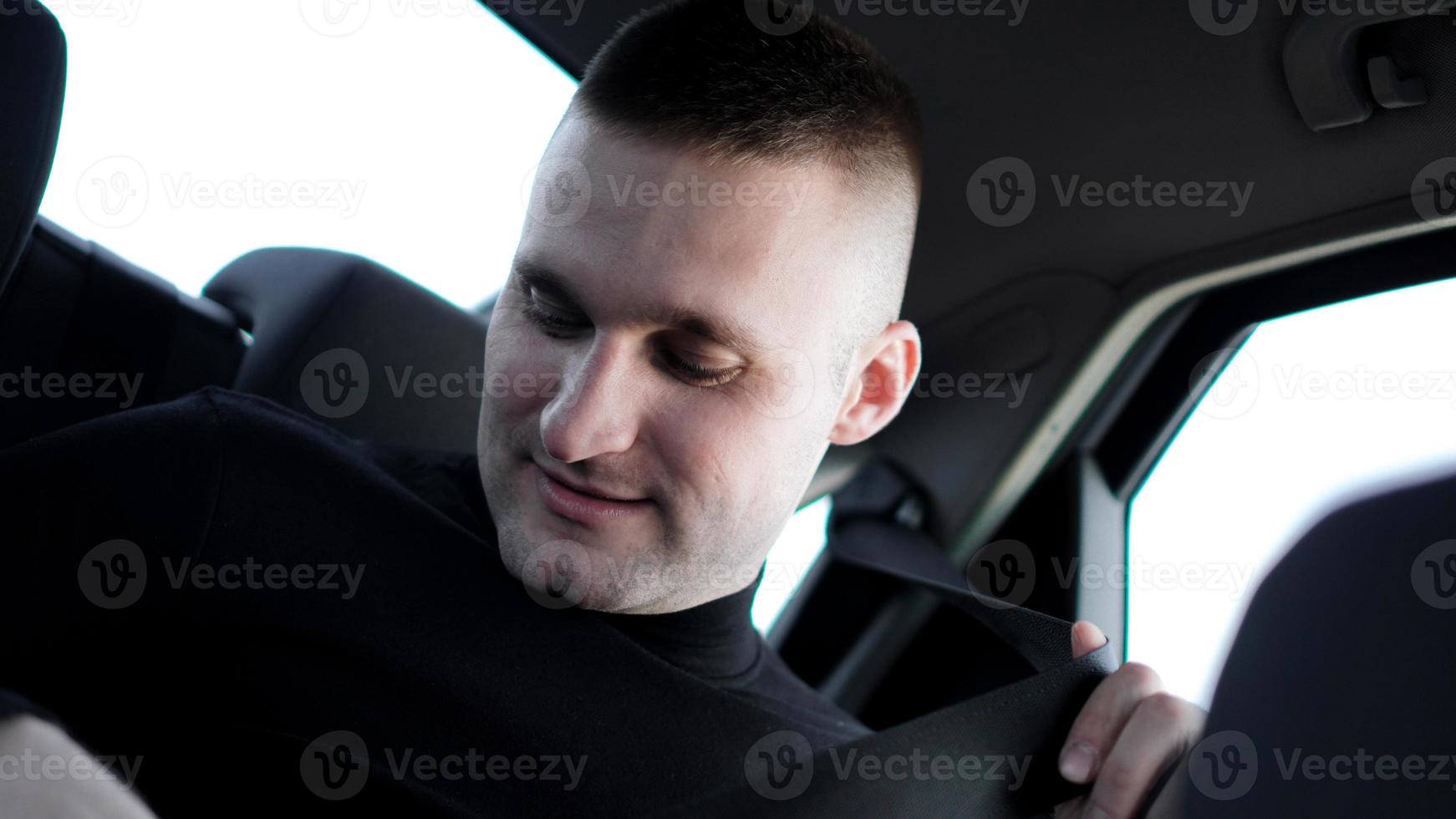 affärsman i sin bil som spänner säkerhetsbältet, säkert körkoncept foto