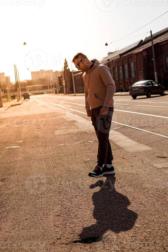 hipster som går på gatan med den röda tegelväggsbyggnaden foto