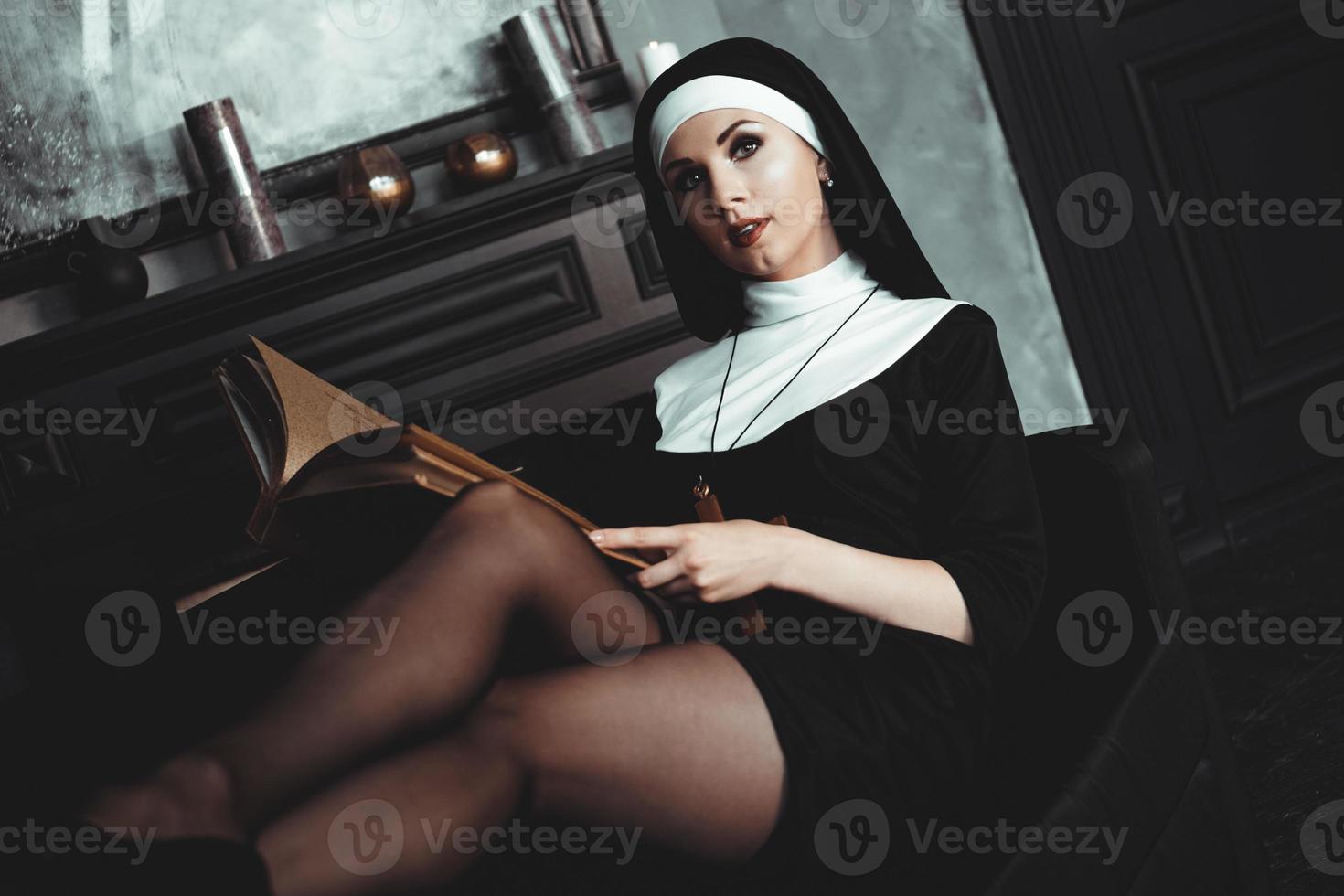 vacker ung nunna i religion svart kostym håller bibeln. religion foto