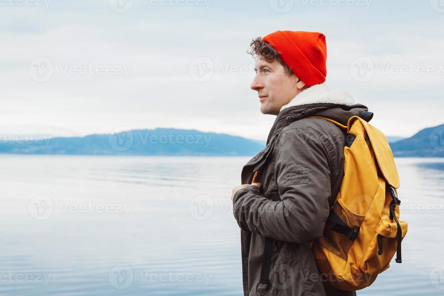 porträtt av en resenär som står på bakgrunden av berg och sjö foto