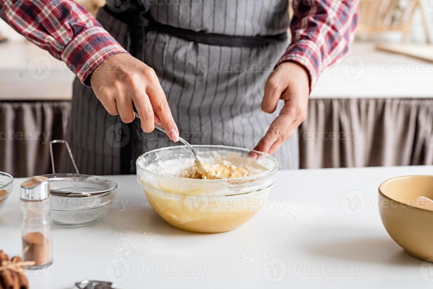 ung latinsk kvinna som blandar degmatlagning i köket foto