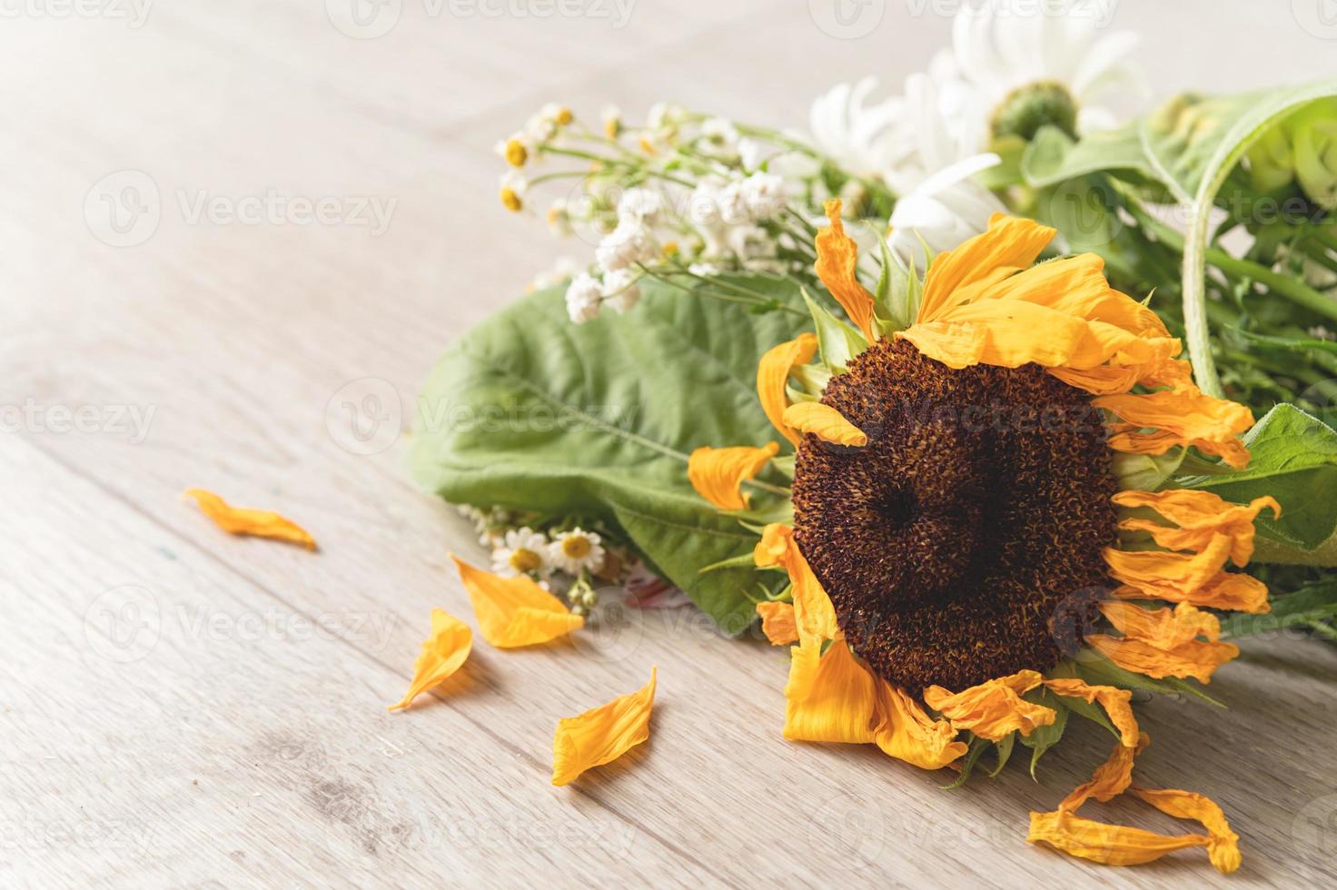 en bukett vissna blommor på golvet foto