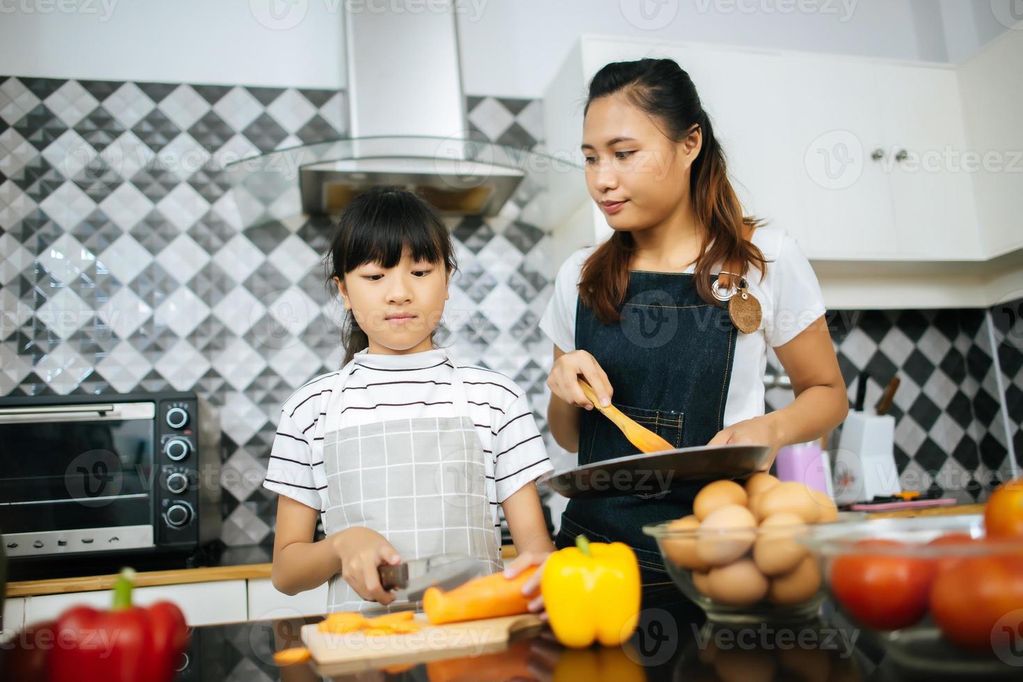 lycklig familj hjälper till att laga måltid tillsammans i köket hemma. foto