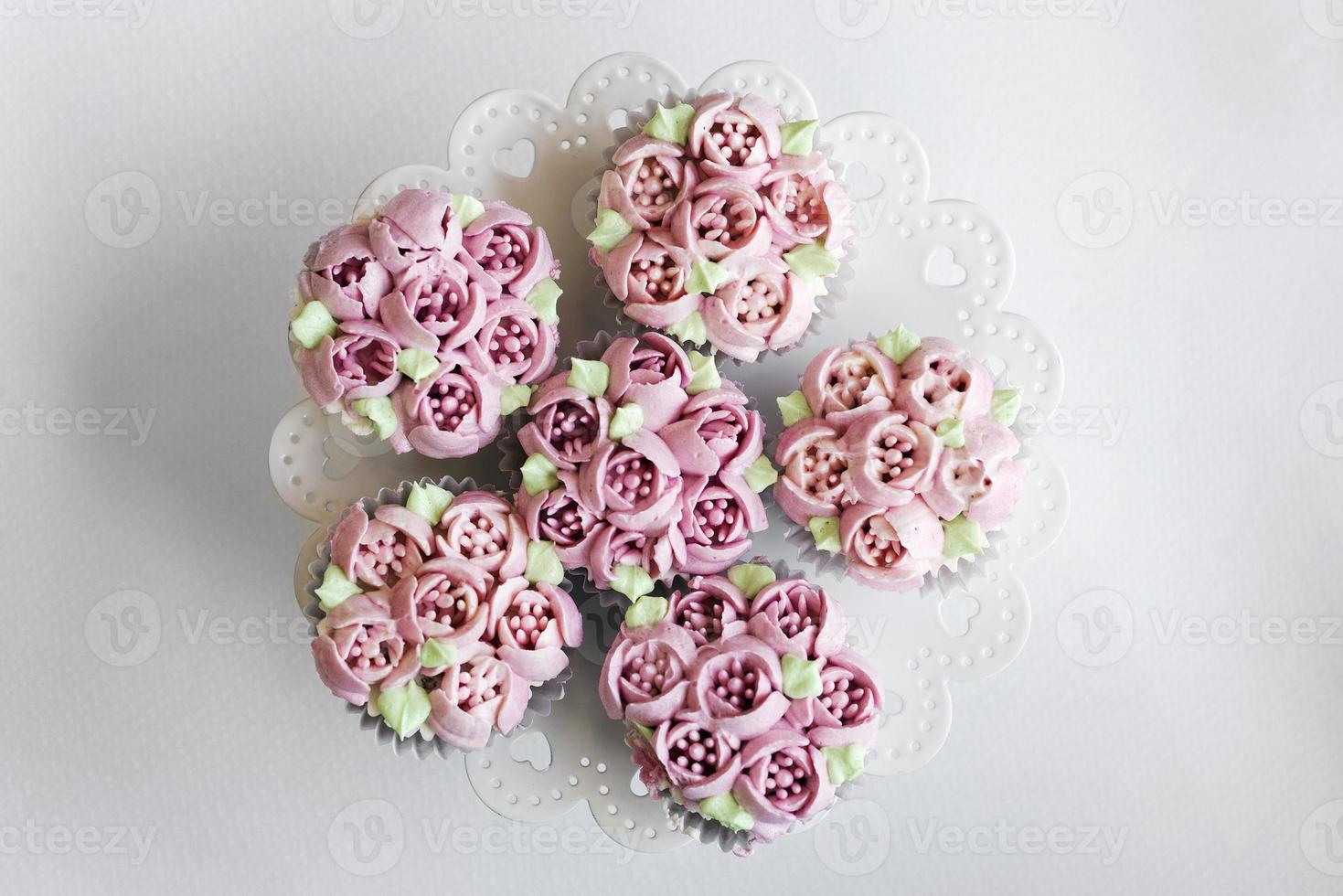 gourmet rosa blomma dekorerade muffins på bordet foto