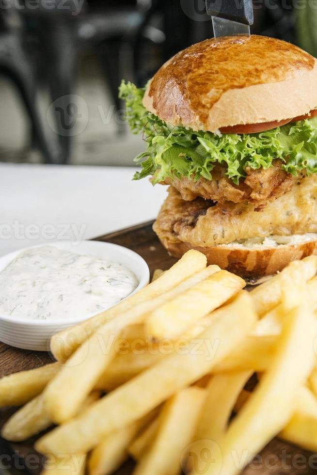 fiskfiléburgare med pommes frites och tartarsås som mellanmål foto