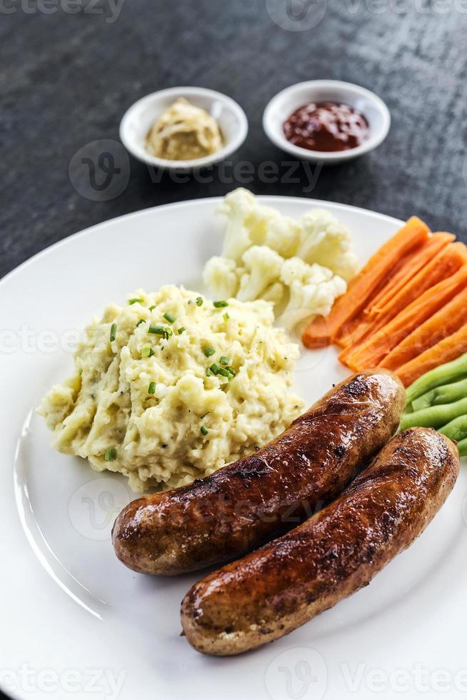 tysk korv med potatismos och grönsaker enkel måltid foto