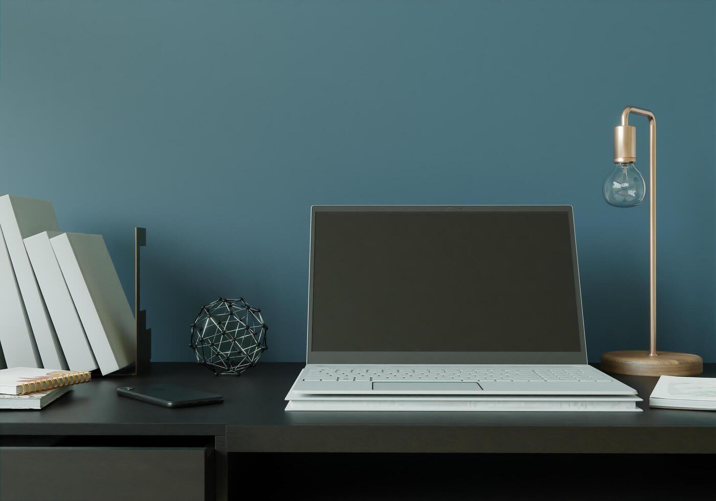 ett arbetsrum med en bärbar dator med en lampa placerad på bordet. foto