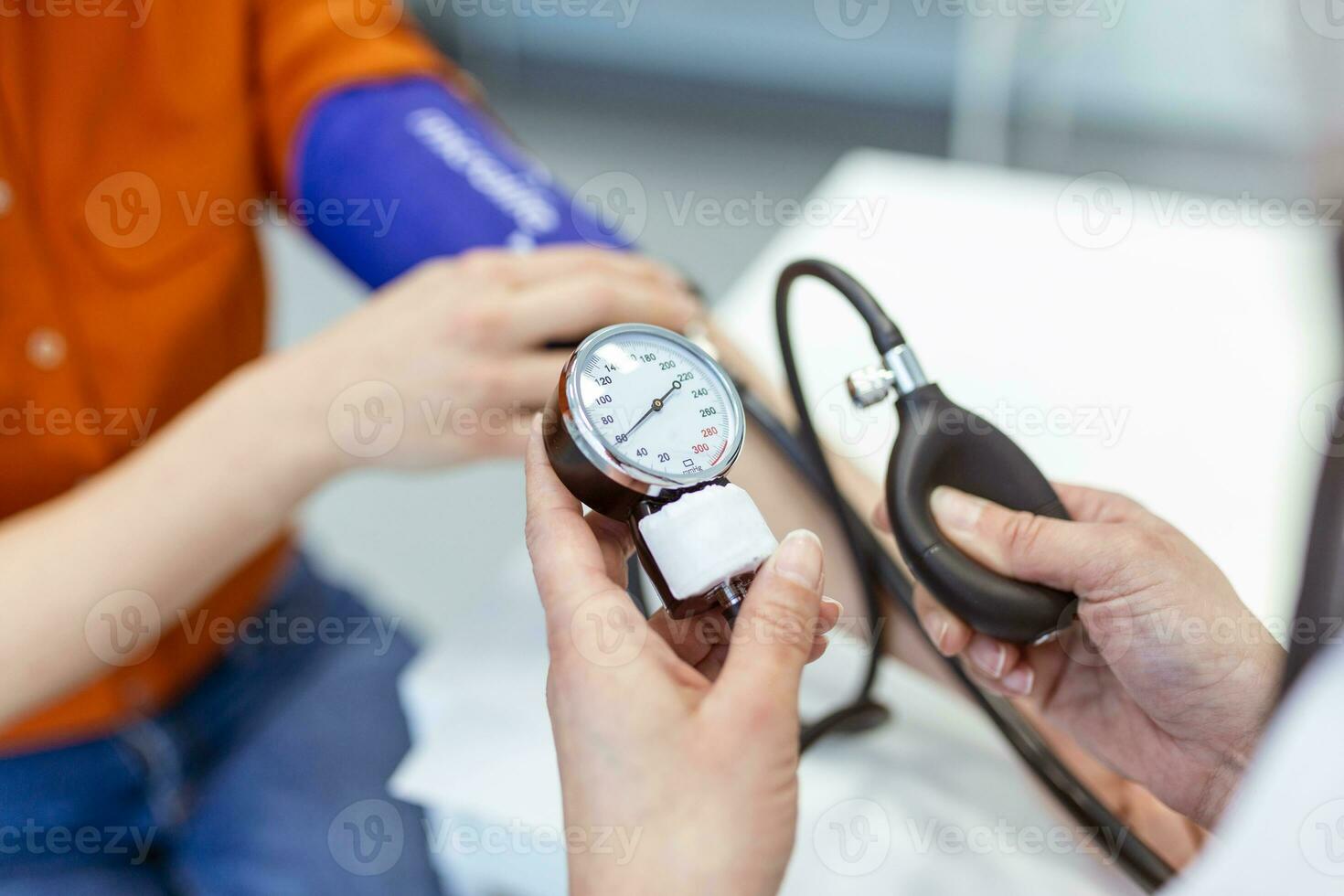 läkare använder sig av sphygmomanometer med stetoskop kontroll blod tryck till en patient i de sjukhus. foto