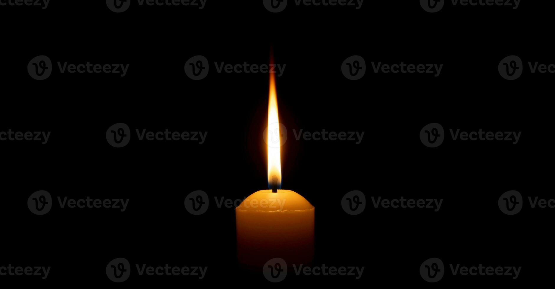 enda brinnande ljus flamma eller ljus lysande på en stor vit ljus på svart eller mörk bakgrund på tabell i kyrka för jul, begravning eller minnesmärke service med kopia Plats. foto