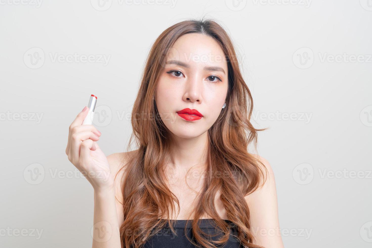 porträtt vacker kvinna sminkar och använder rött läppstift foto