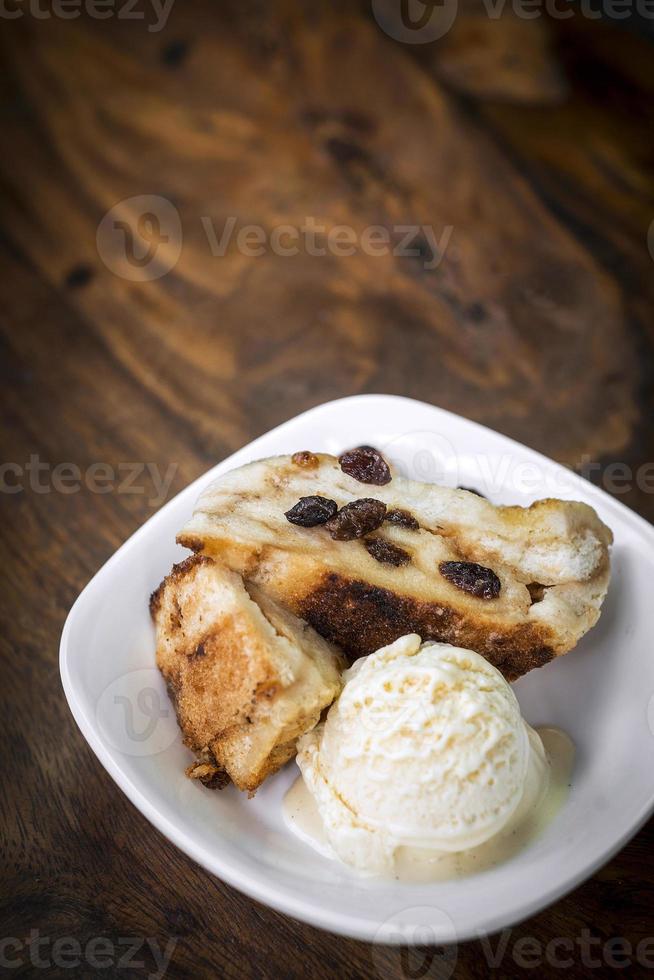 brittisk traditionell brödpudding med vaniljglass efterrätt foto