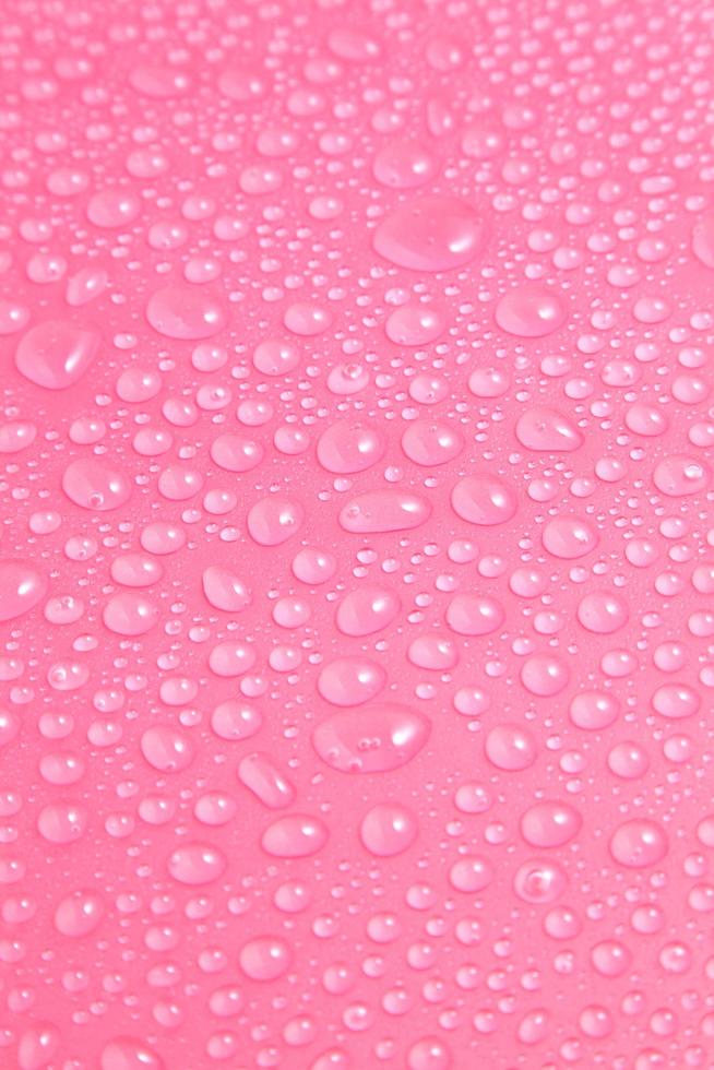 närbild vattendroppar på rosa bakgrund foto