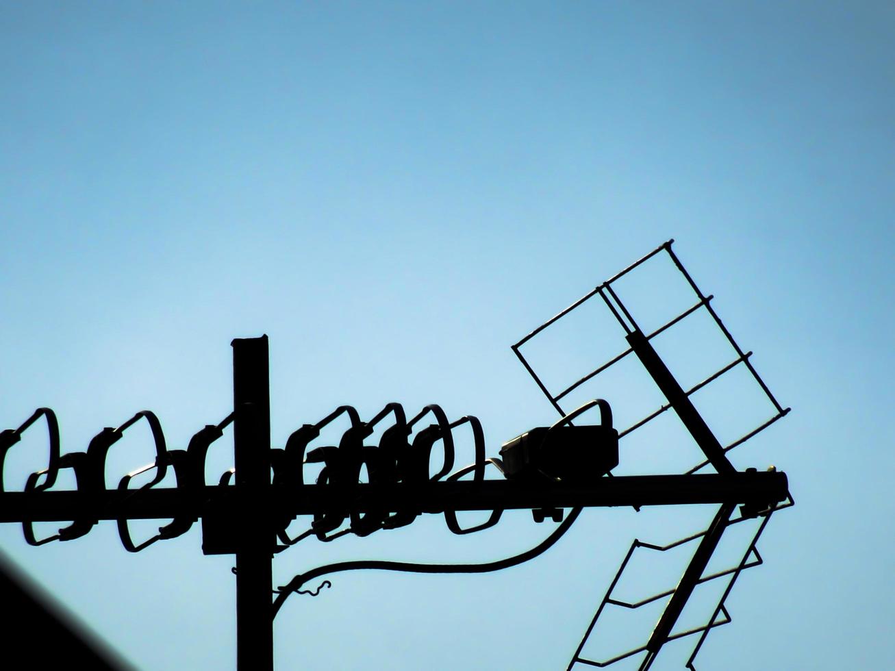 TV -antenner med blå himmel bakgrund foto