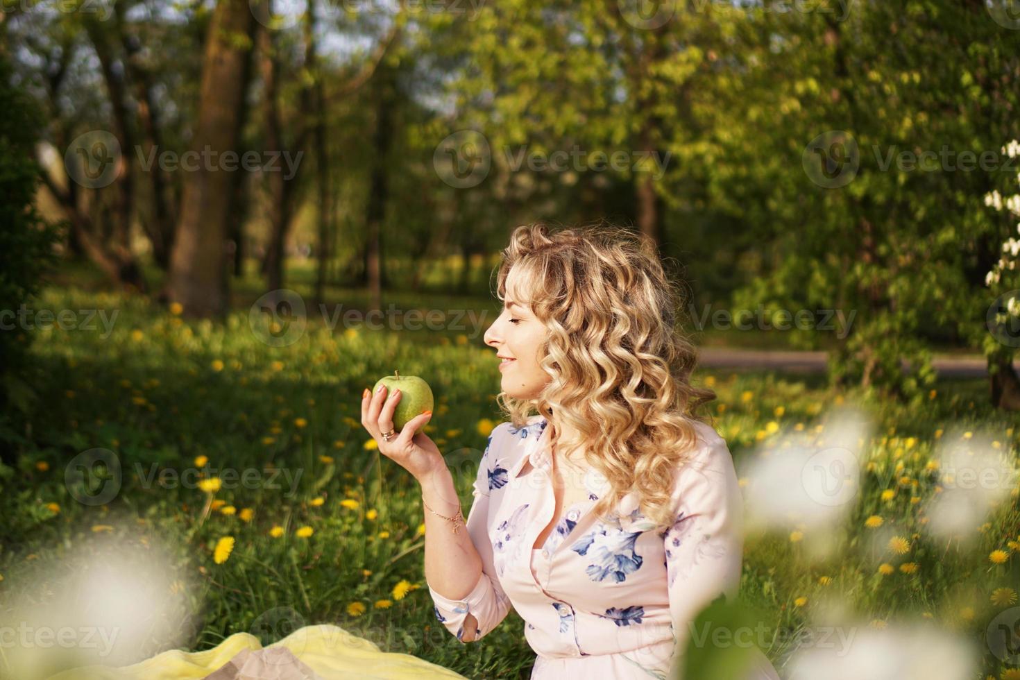 kvinna med äpple på en picknick i sommarträdgården foto