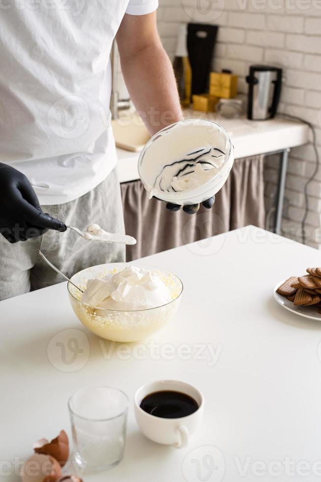 kock i jultomten som lagar en dessert i köket foto