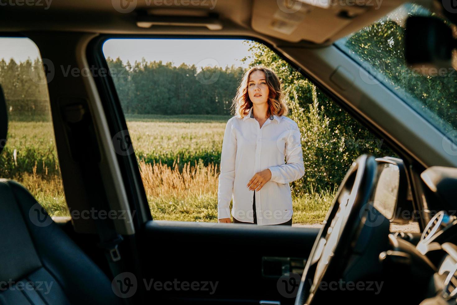 en vacker ung kvinna i en vit skjorta vilar utanför staden foto