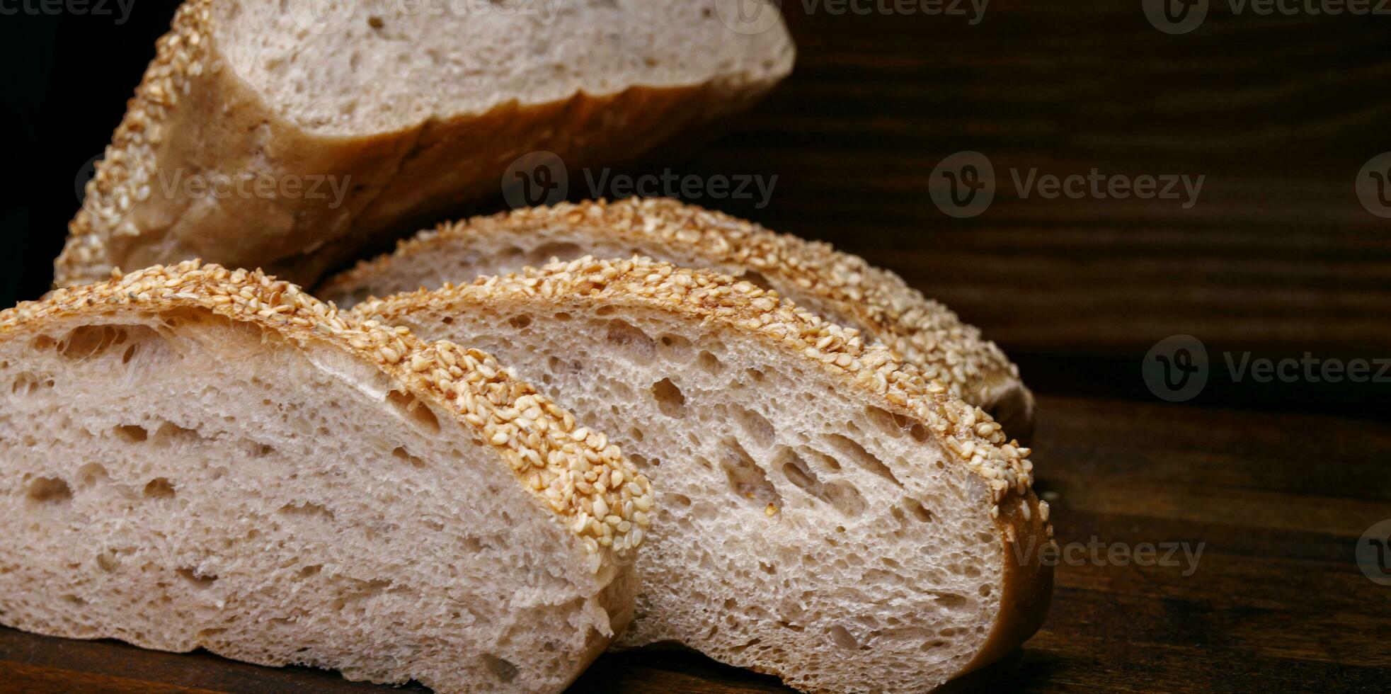 skära limpa av bröd och bitar av bröd på en trä- bakgrund. ciabatta bröd. foto