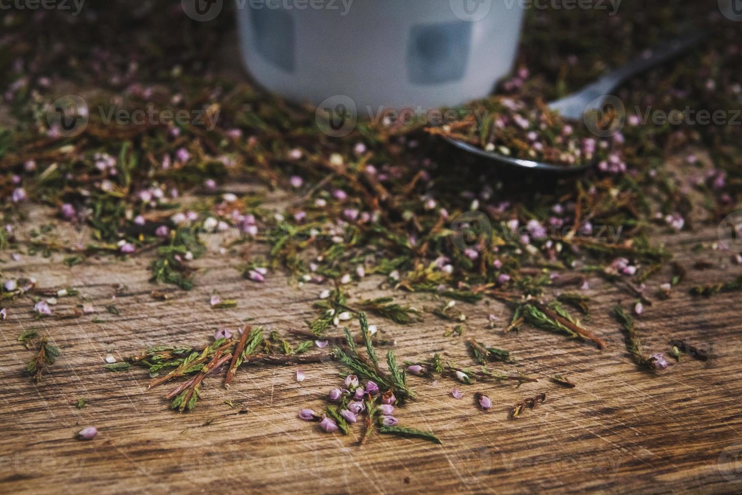 kopp och sked med blommigt te på en träbakgrund foto