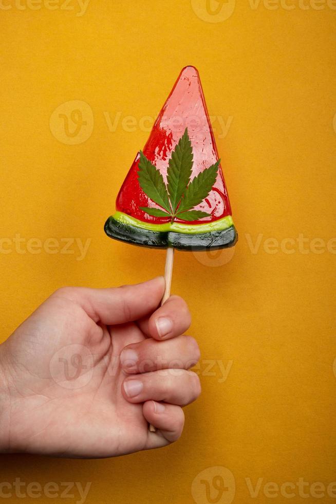 vattenmelon söt slickepinne med cannabis thc i en kvinnas hand. foto