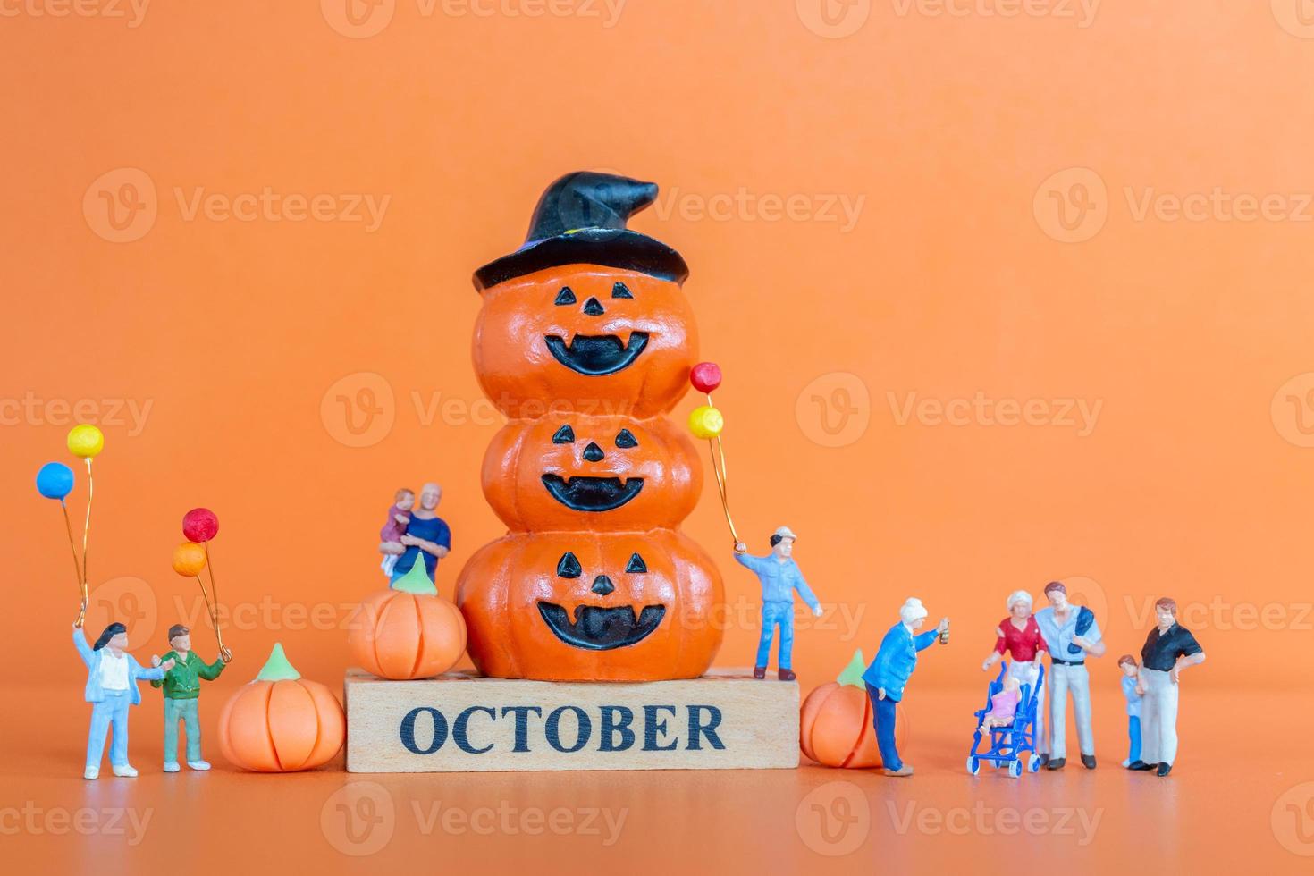 miniatyr människor lycklig familj med pumpa på orange bakgrund foto