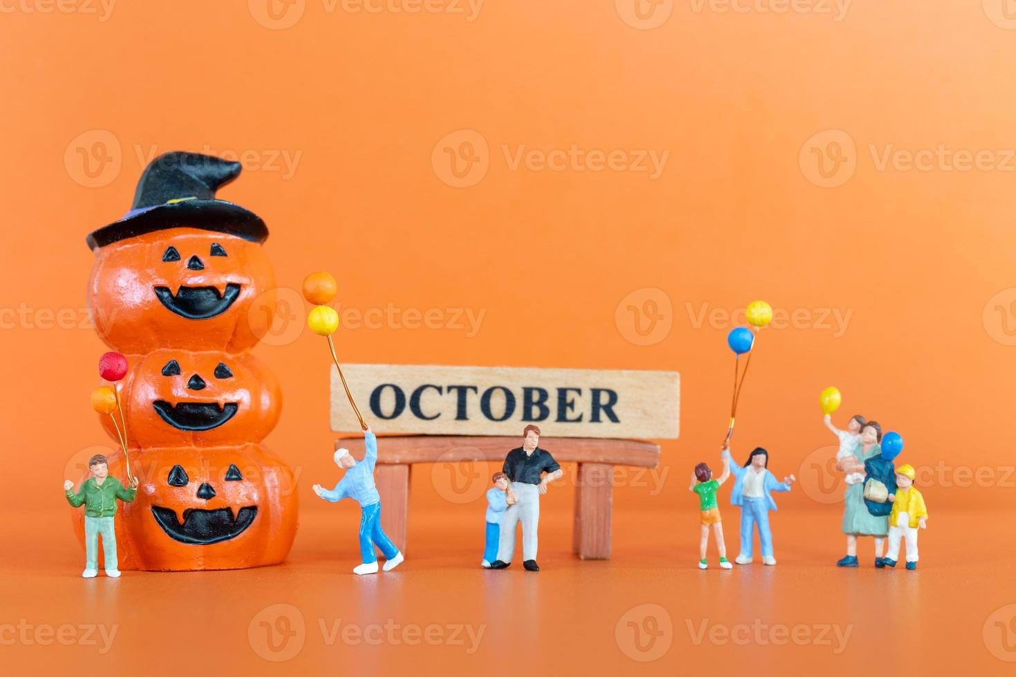 miniatyr människor lycklig familj med pumpa på orange bakgrund foto