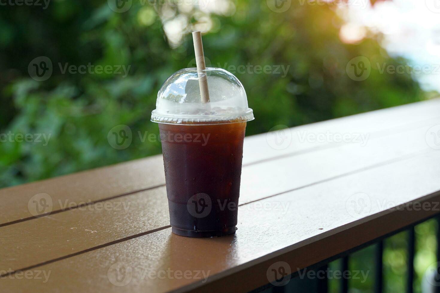 iced kaffe kopp på en trä- tabell i en kaffe affär den är en dryck med en stark smak den där är utsökt och uppfriskande till äta. den är en populär meny den där kunder kärlek. foto