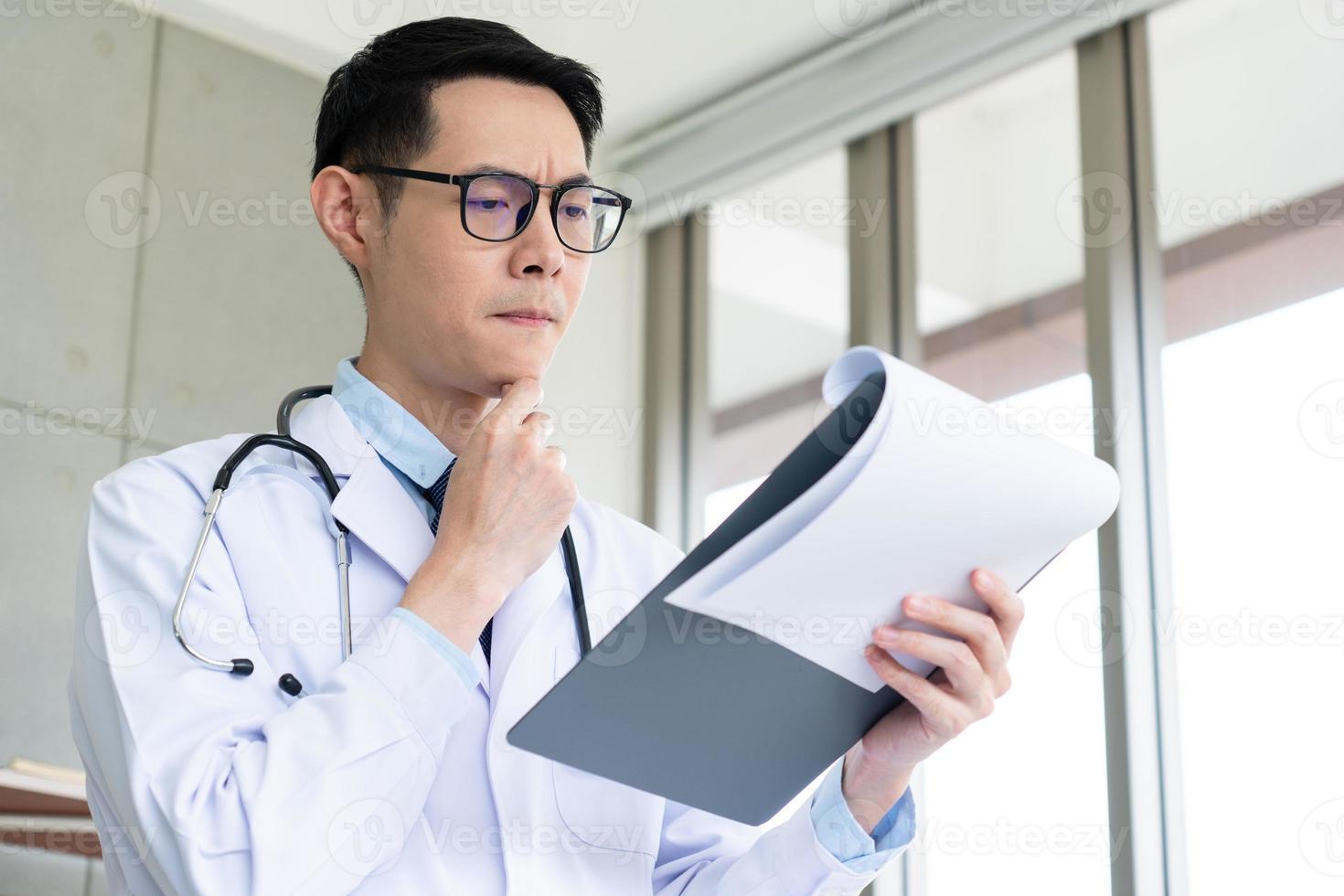 läkare som läser patientdiagram foto