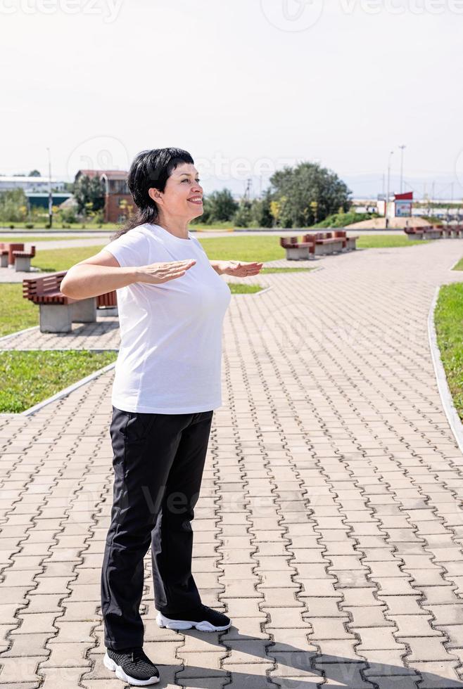 le kvinna gör uppvärmning innan träning utomhus i parken foto