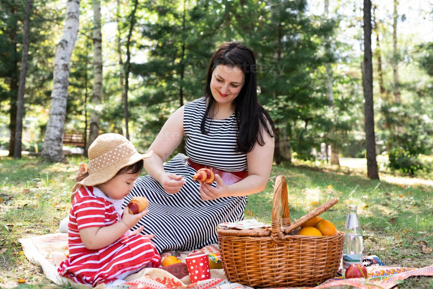 interracial familj av mor och dotter i parken som har en picknick foto