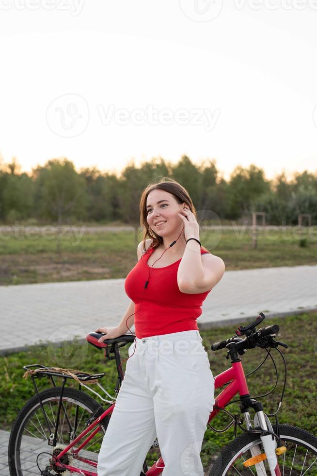 tonårsflicka med sin cykel som lyssnar på musiken foto