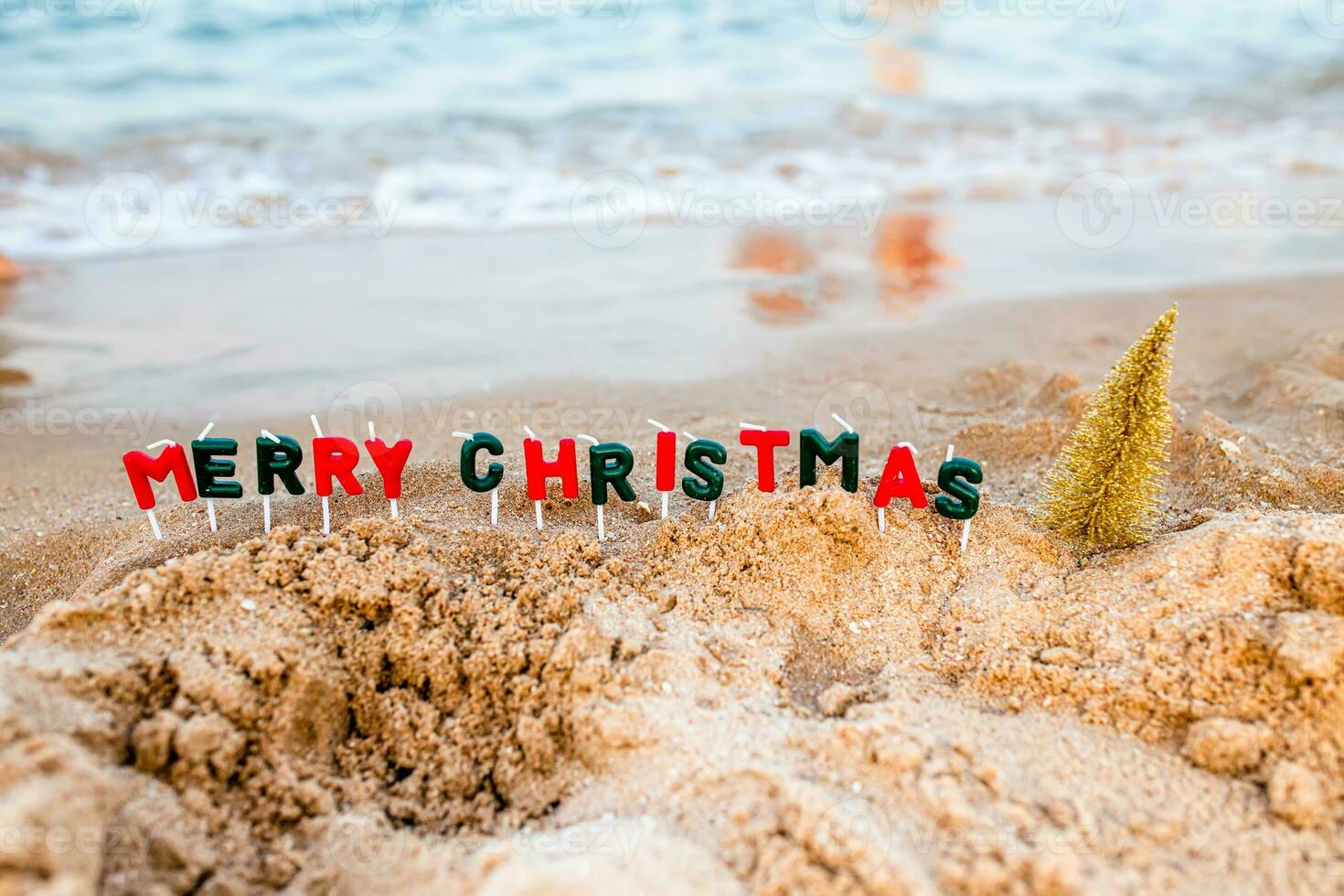 de havsstrand med en rullande Vinka på de dekorerad för jul.. text från glad jul ljusstakar foto
