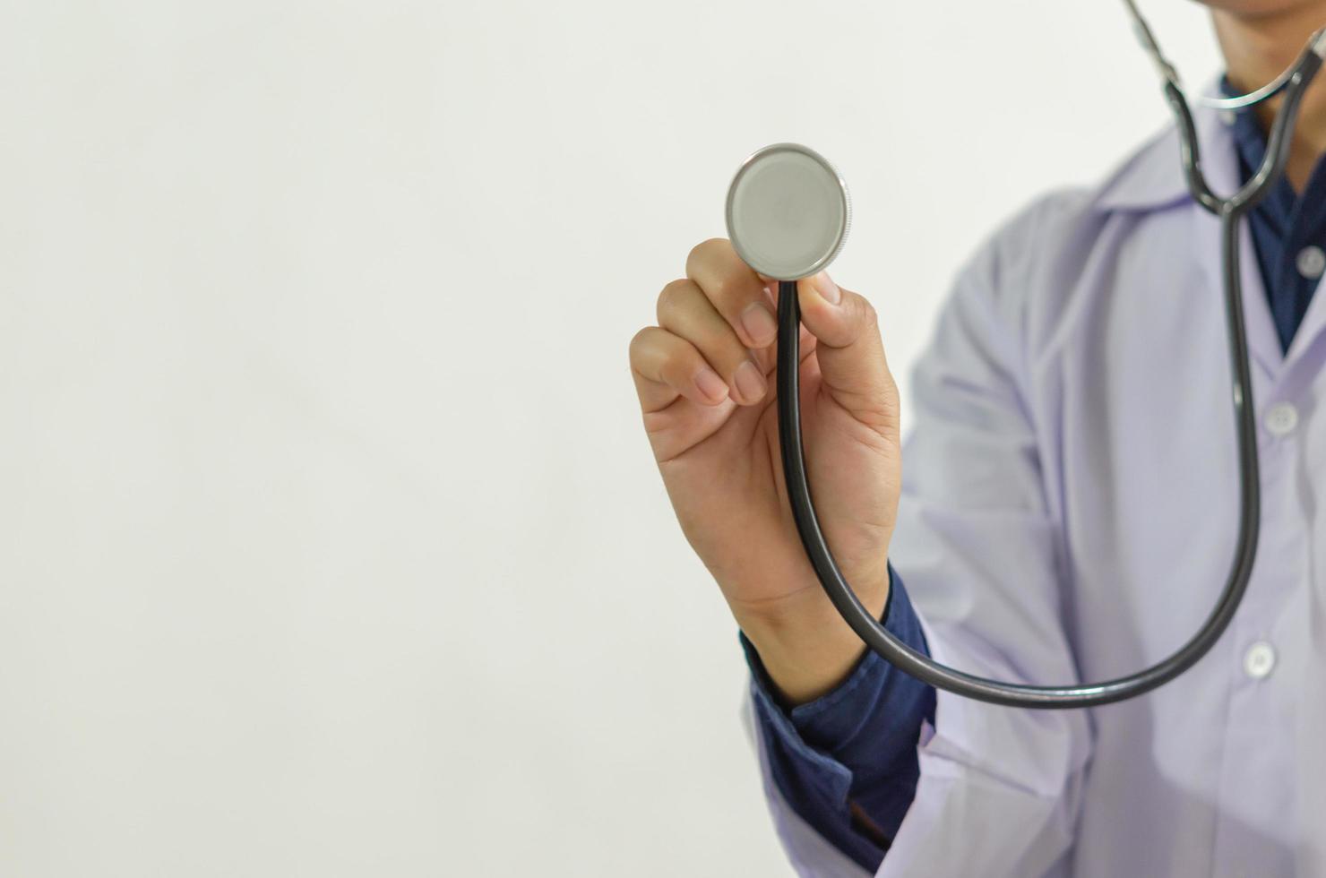 närbild av doktorns hand som håller ett medicinskt stetoskop foto