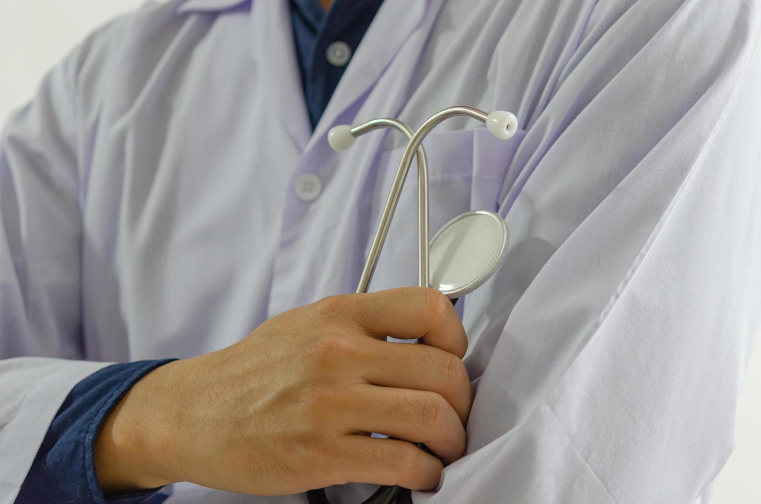 närbild av doktorns hand som håller ett medicinskt stetoskop foto