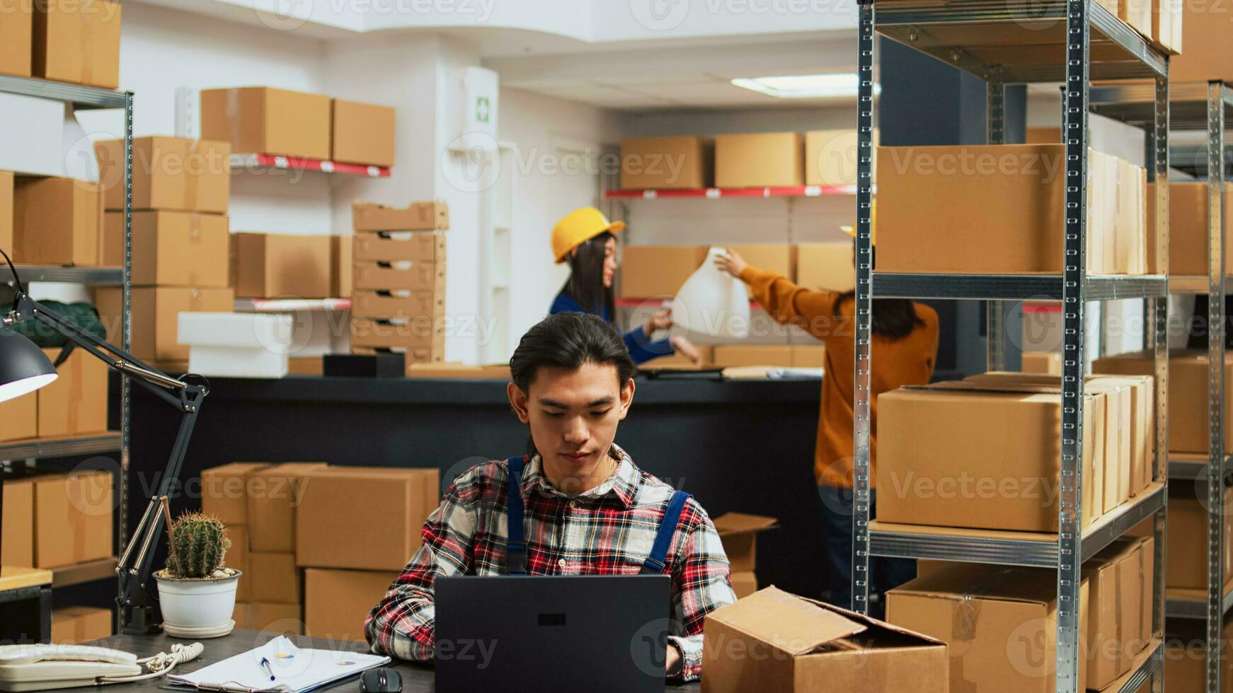 asiatisk arbetstagare som visar lager leveranser till ägare, människor arbetssätt på Produkter kvalitet kontrollera i lagring rum. team av anställda ser på handelsvaror i lådor, företag planen. foto