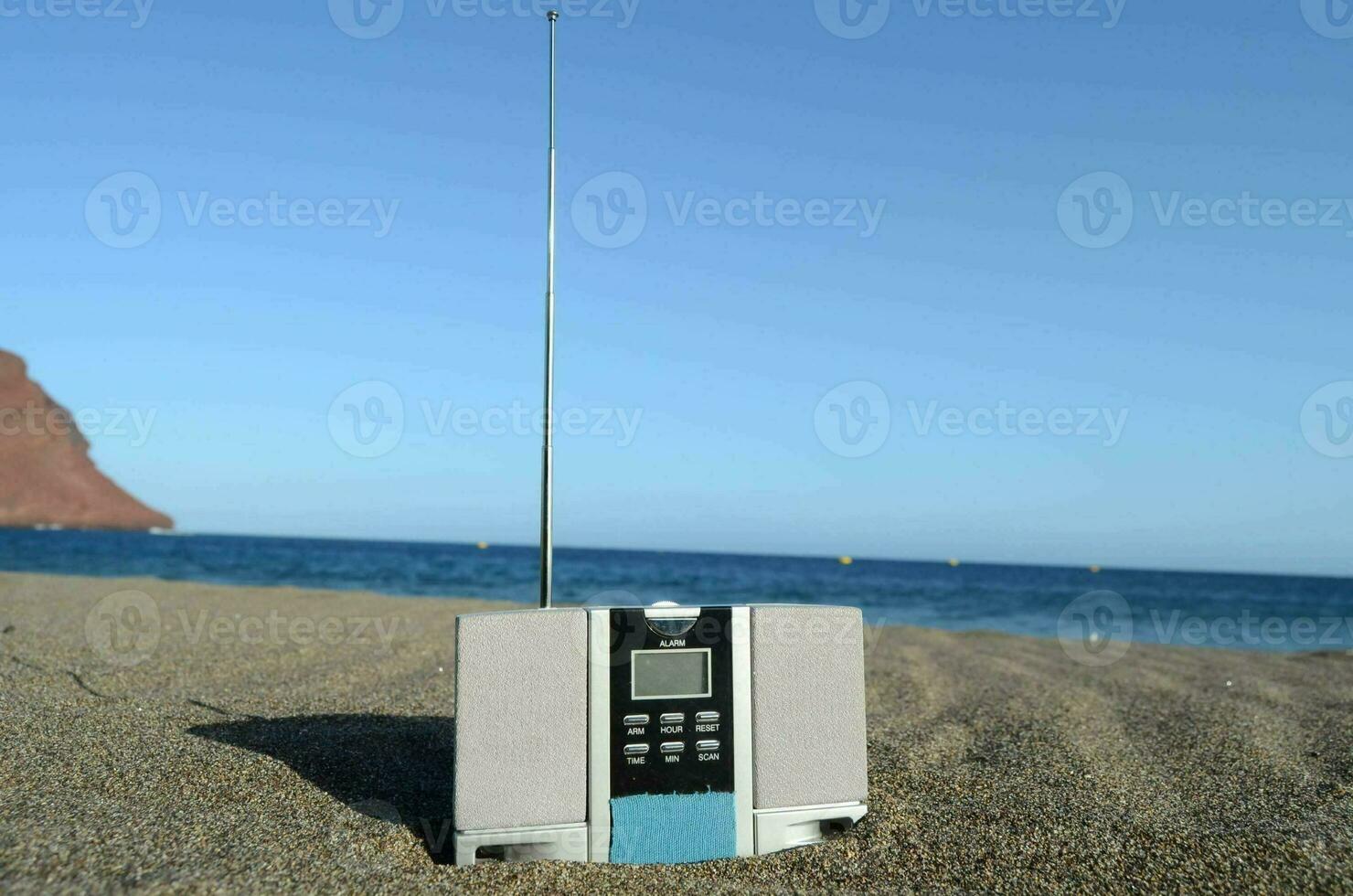 en radio Sammanträde på de sand nära de hav foto