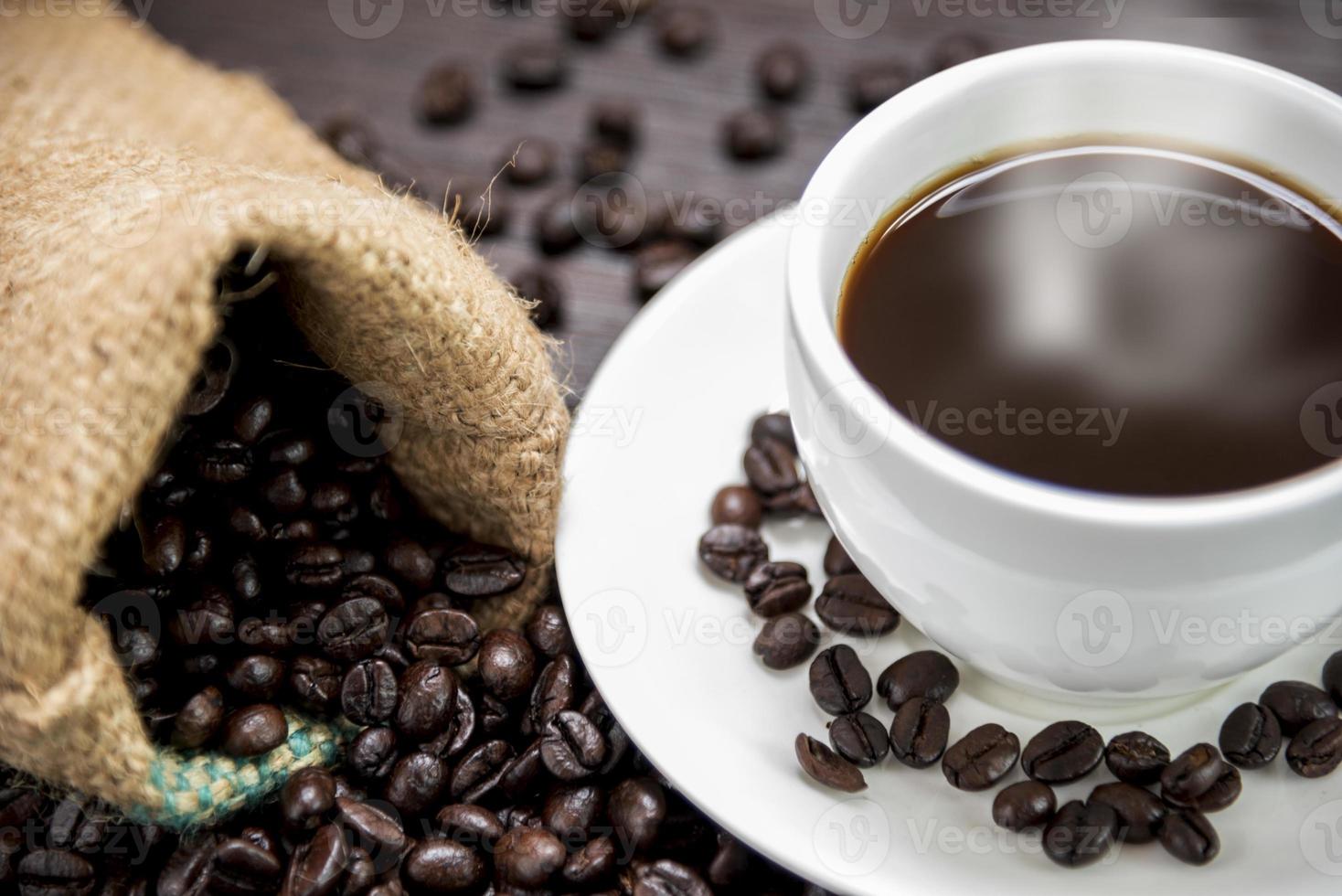 kaffekopp med rök och kaffebönor foto