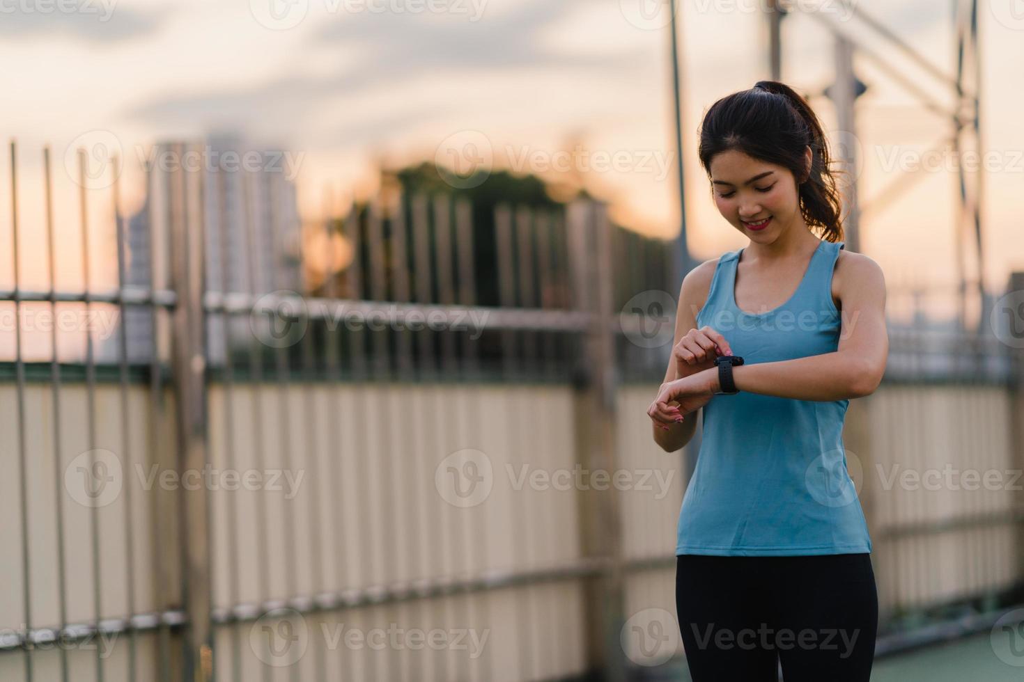 Asien friidrottare dam övningar kontrollera pulsmätare på smartwatch. foto