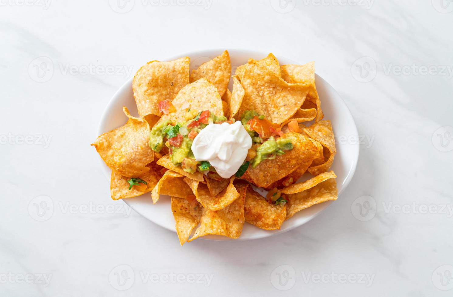 nachos tortillachips med jalapeno, guacamole, tomatsalsa och dopp foto