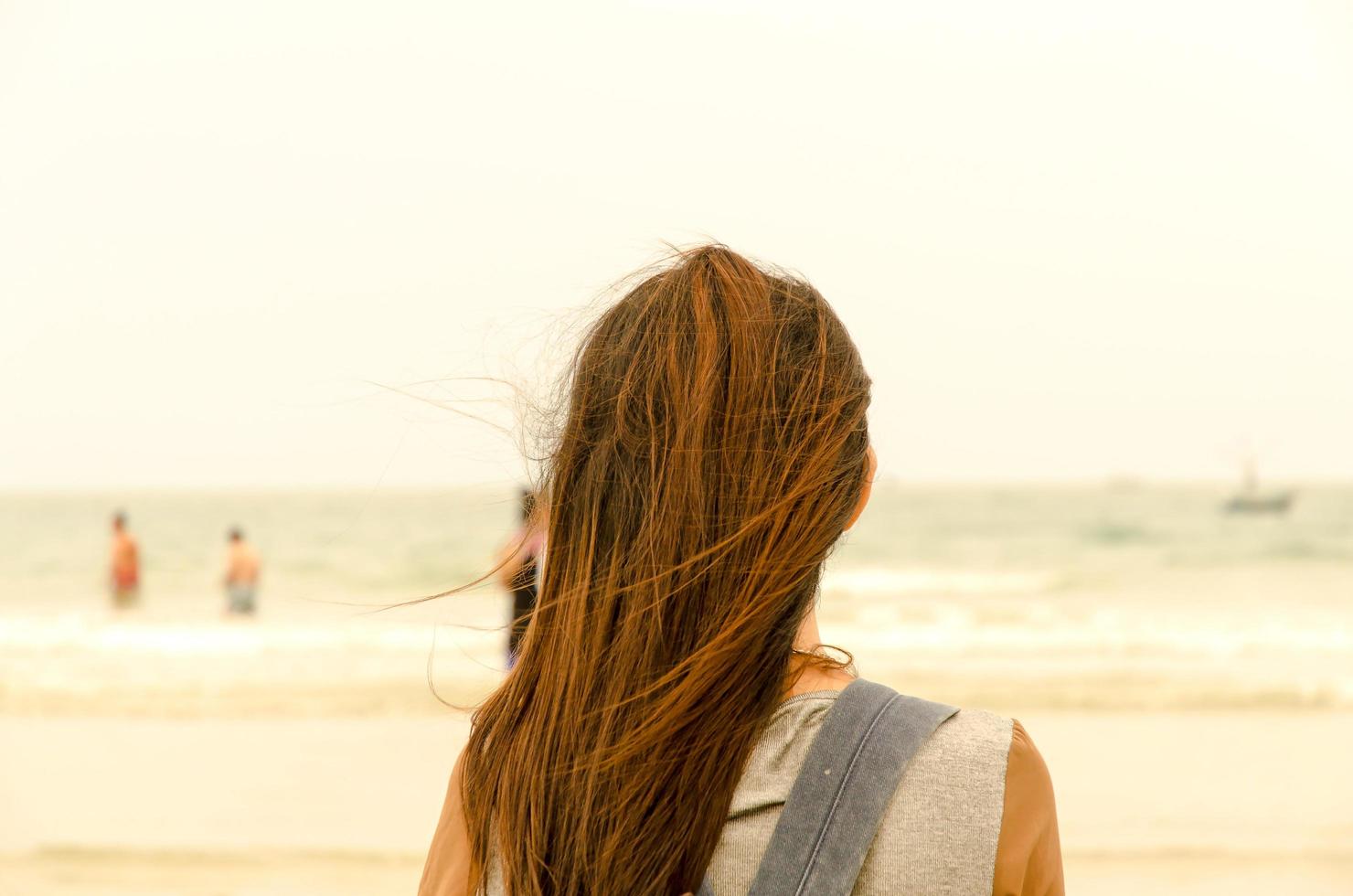 resenären står på sandstranden och ser hur folk simmar foto