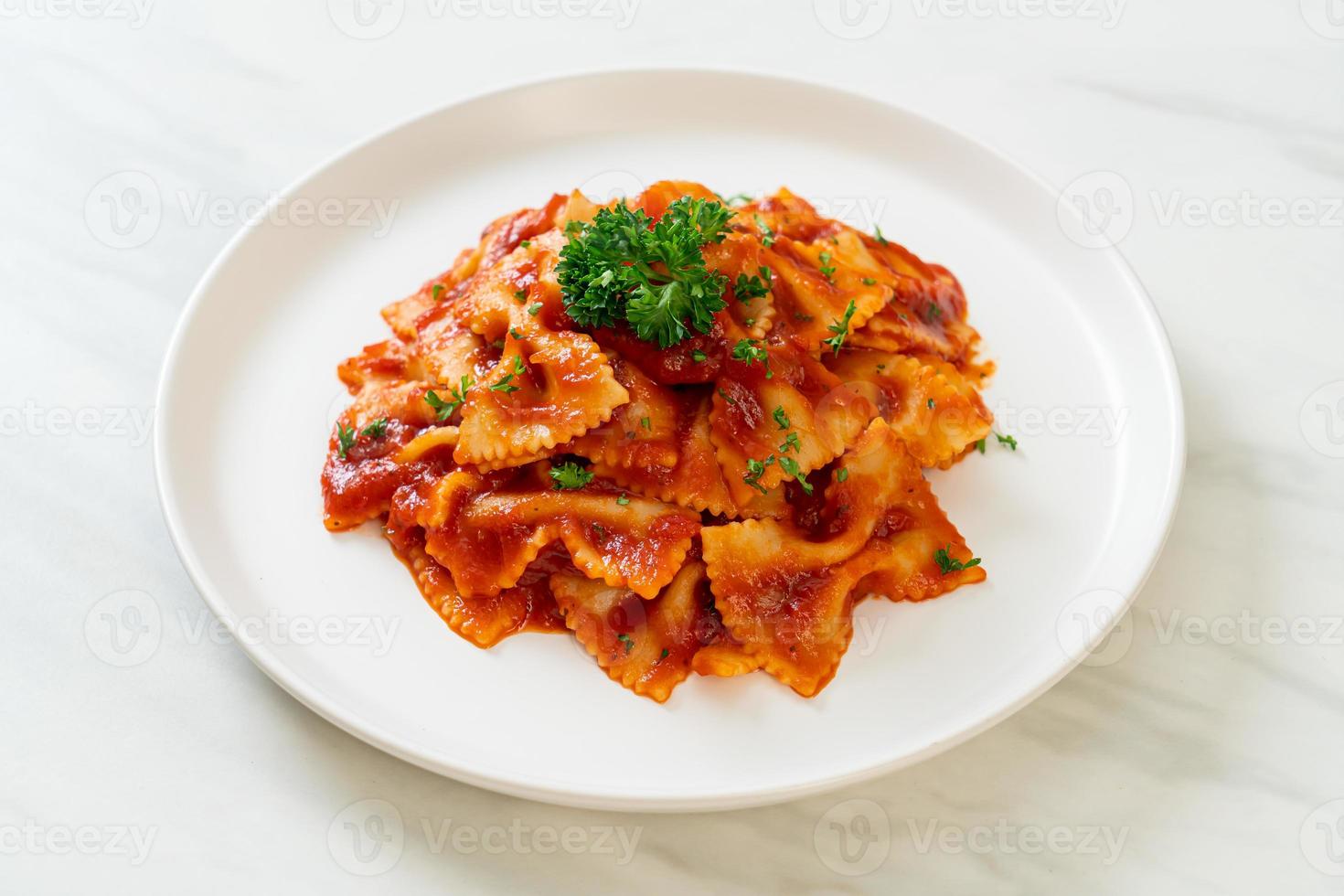 farfalle pasta i tomatsås med persilja foto