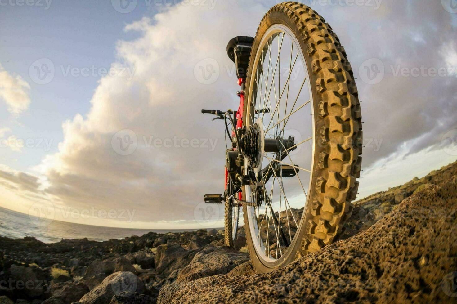 en berg cykel är parkerad på de stenar nära de hav foto