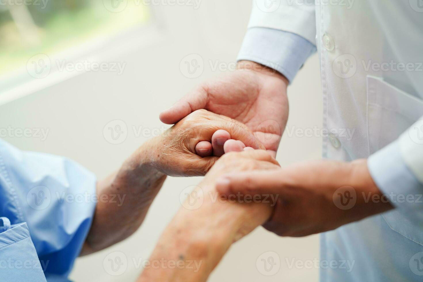 läkare håller händerna asiatisk äldre kvinna patient, hjälp och vård på sjukhus. foto