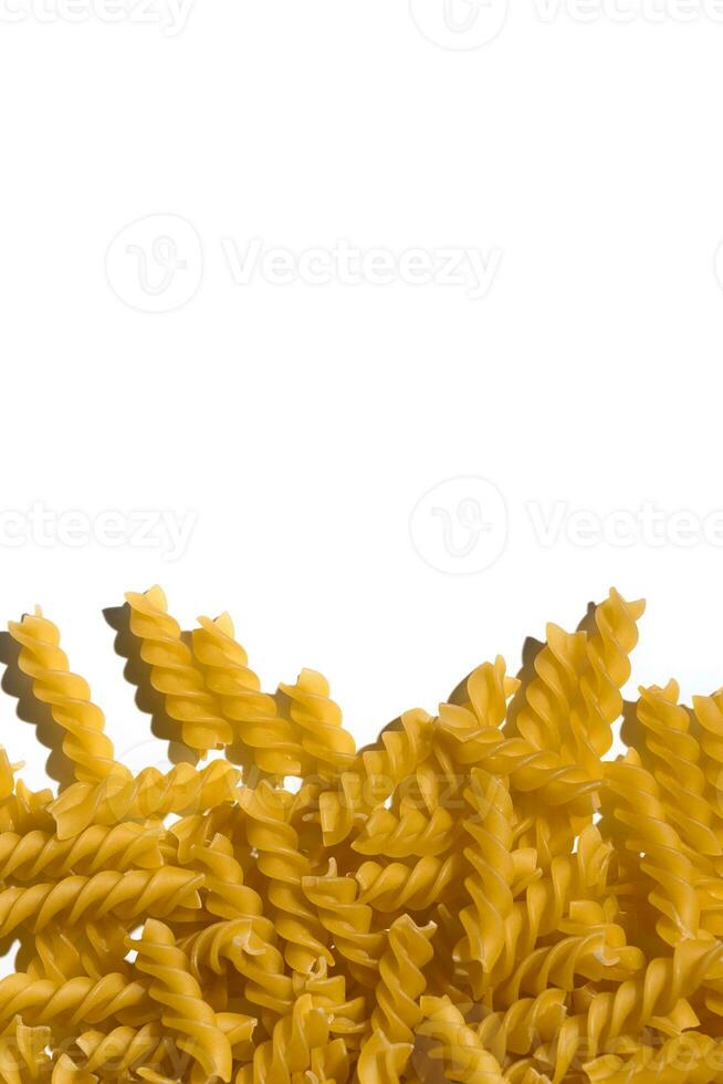 vertikal bild av rå spiral durum vete semolinagryn pasta på vit bakgrund, topp se, kopia Plats foto