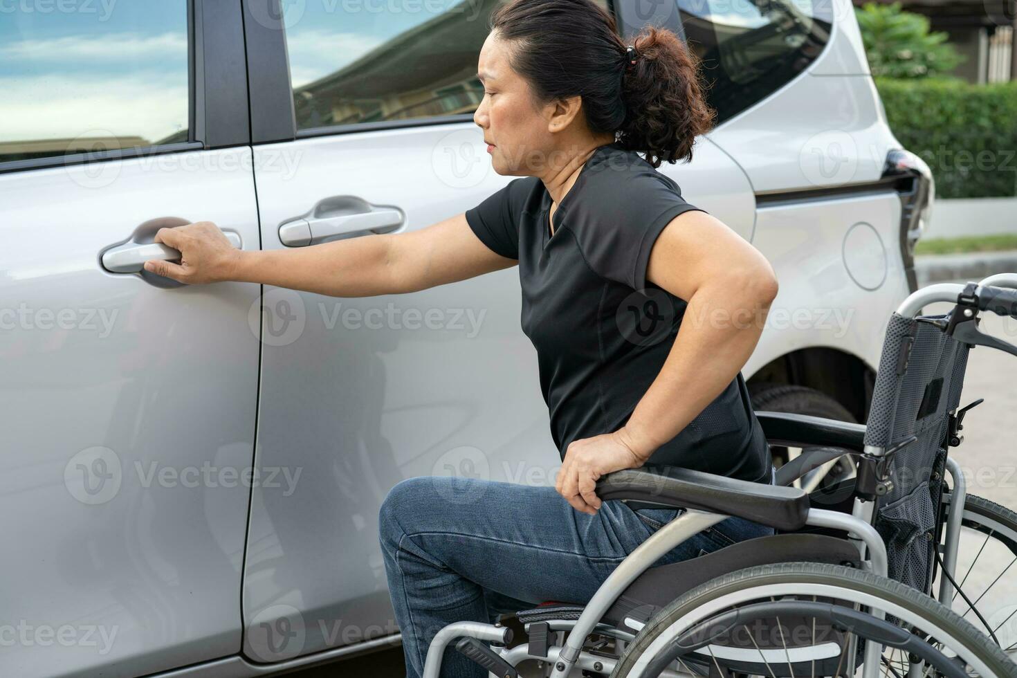 asiatisk handikapp kvinna på rullstol få i henne bil, tillgänglighet begrepp. foto
