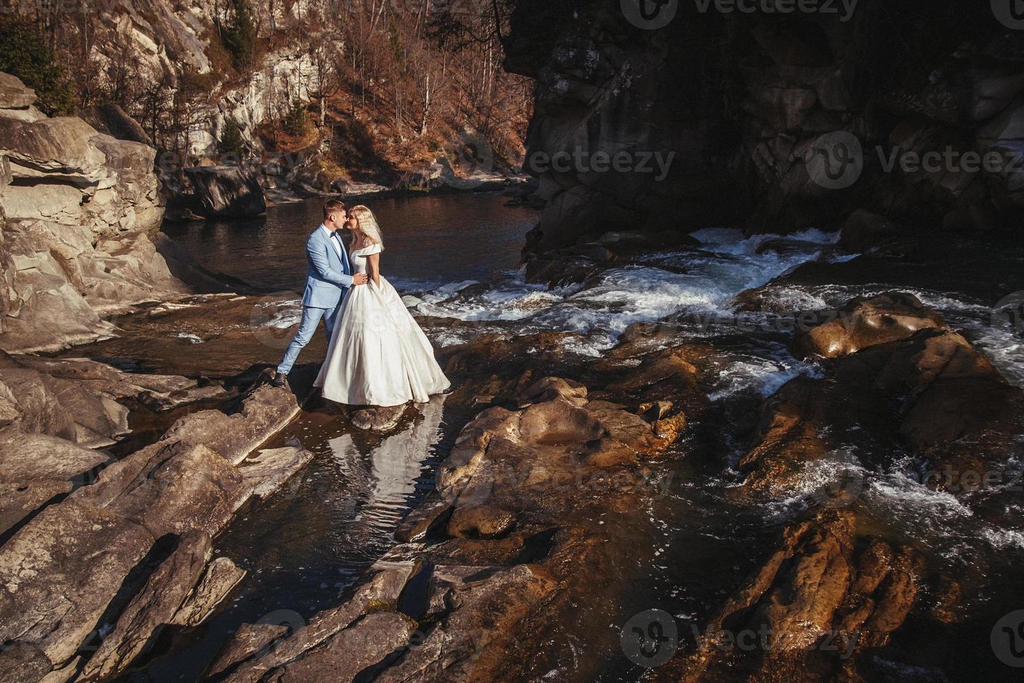 gift par som omfamnar med ett berg och en flodbakgrund foto