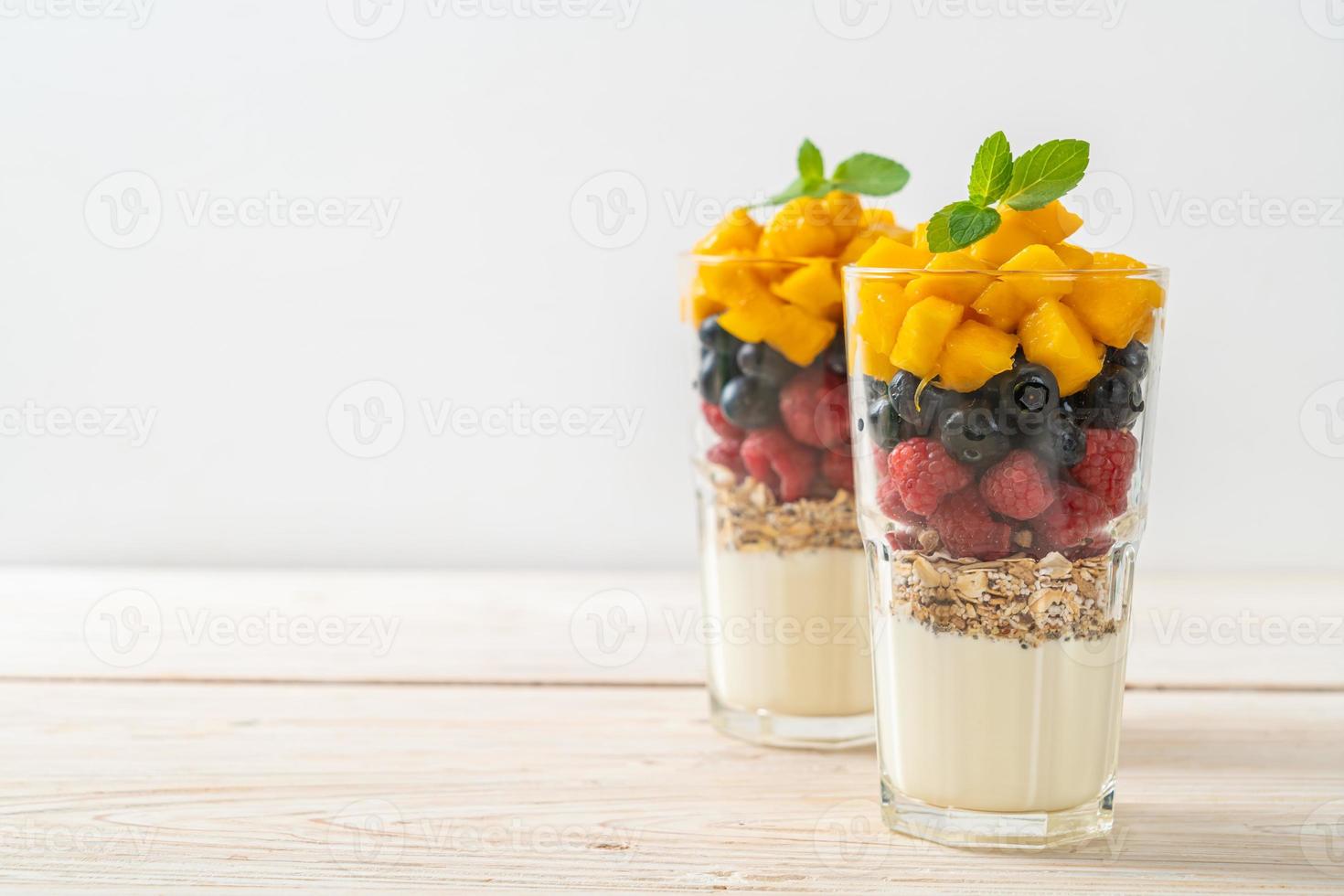 hemlagad mango, hallon och blåbär med yoghurt och granola foto