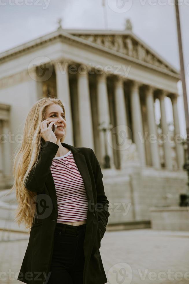 vacker leende kvinna med mobiltelefon och promenader foto